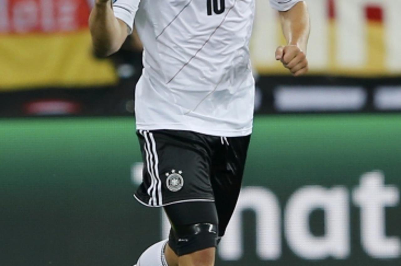 'Germany\'s Lukas Podolski celebrates after scoring a goal against Denmark during their Euro 2012 Group B soccer match at the new stadium in Lviv June 17, 2012.          REUTERS/Thomas Bohlen (UKRAINE