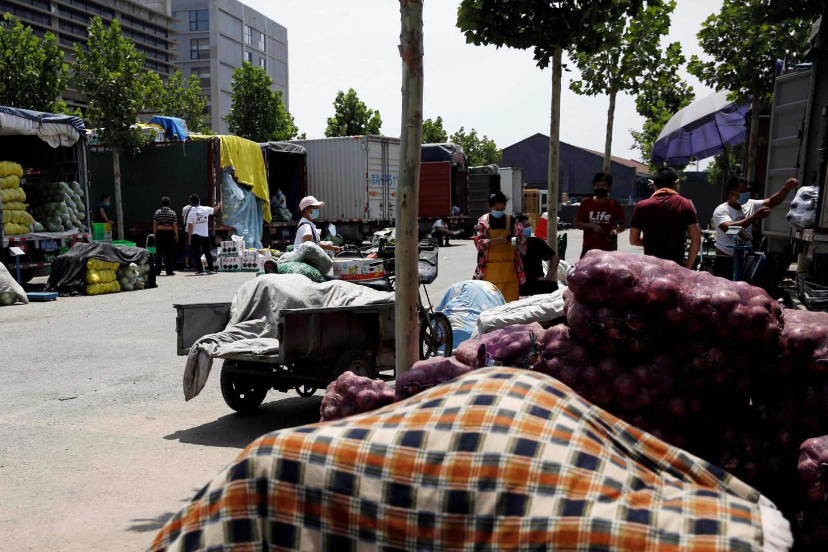 Trucks with vegetables are seen at a temporary wholesale market in Beijing Trucks with vegetables are seen at a temporary wholesale market after the Xinfadi wholesale market nearby was closed following cases of the coronavirus disease (COVID-19) infections, in Beijing, China June 16, 2020.  REUTERS/Tingshu Wang TINGSHU WANG