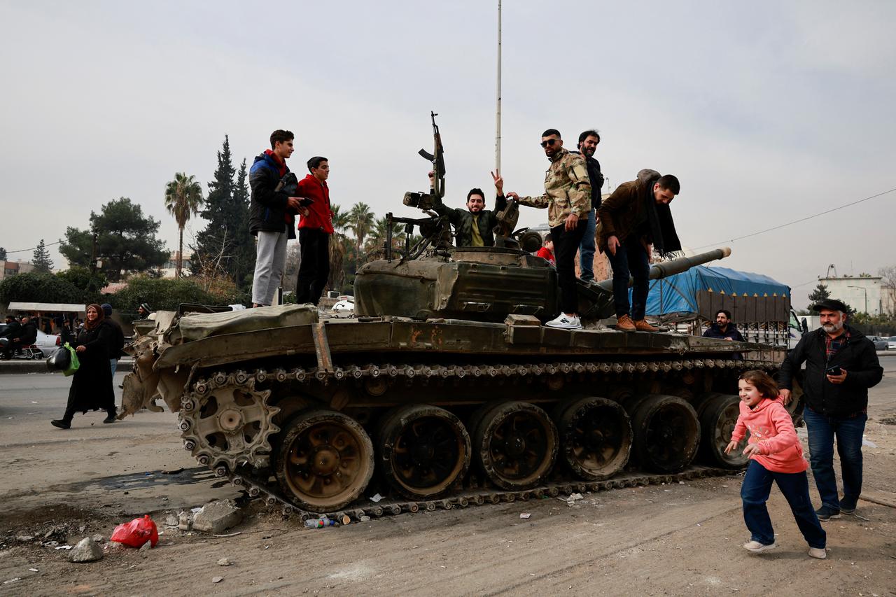 People celebrate after rebels seized the capital and announced that they have ousted President Bashar al-Assad, in Sednaya