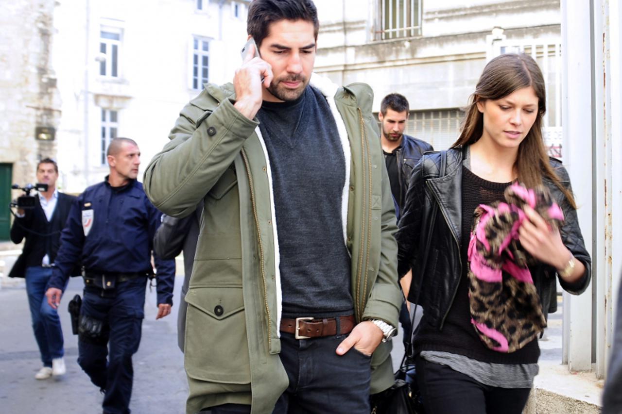 'French handball player of Montpellier Nikola Karabatic (C), suspected of match-fixing and illegal betting, and his companion Geraldine Pillet (R) leave the Montpellier\'s courthouse, southern France,