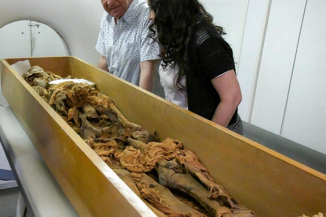 Zahi Hawass, an Egyptologist, stands next to assistant as a mummy, said to be belonging to an ancient Egyptian King, is put through a CT scanner in Egypt