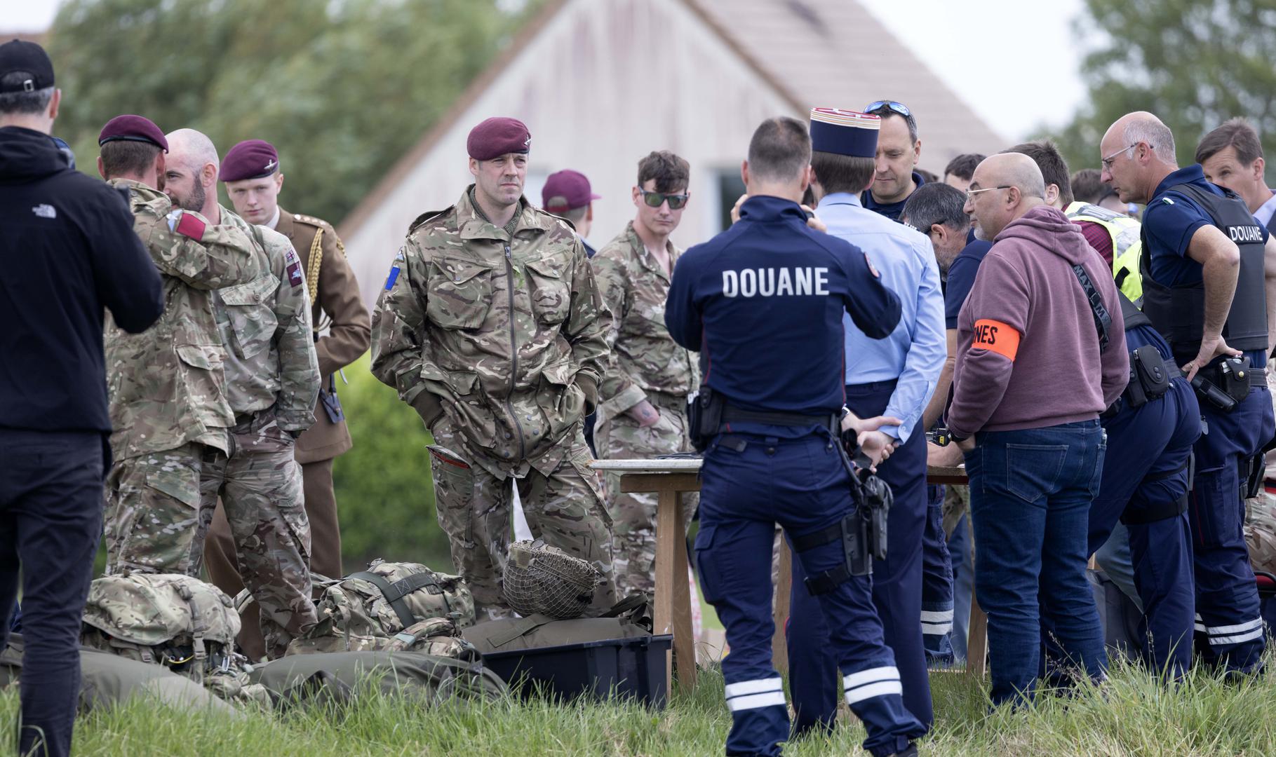 Paratroopers queue to show their passports to French customs control after landing in a field after making a commemorative jump into fields around the French village of Sanneville in Normandy as part of the 80th anniversary of D-day. 05.06.2024   Material must be credited "The Times/News Licensing" unless otherwise agreed. 100% surcharge if not credited. Online rights need to be cleared separately. Strictly one time use only subject to agreement with News Licensing Photo: Richard Pohle/NEWS SYNDICATION