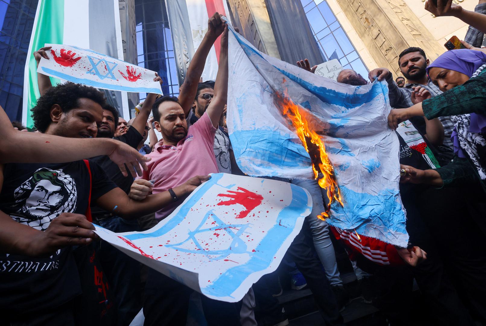 Demonstrators burn a banner depicting the Israeli flag during a protest against Israel and the USA in support of Palestinians for those killed in a blast at Al-Ahli hospital in Gaza that Israeli and Palestinian officials blamed on each other, amid the ongoing conflict between Israel and Hamas, in Cairo, Egypt, October 18, 2023. REUTERS/Amr Abdallah Dalsh Photo: AMR ABDALLAH DALSH/REUTERS