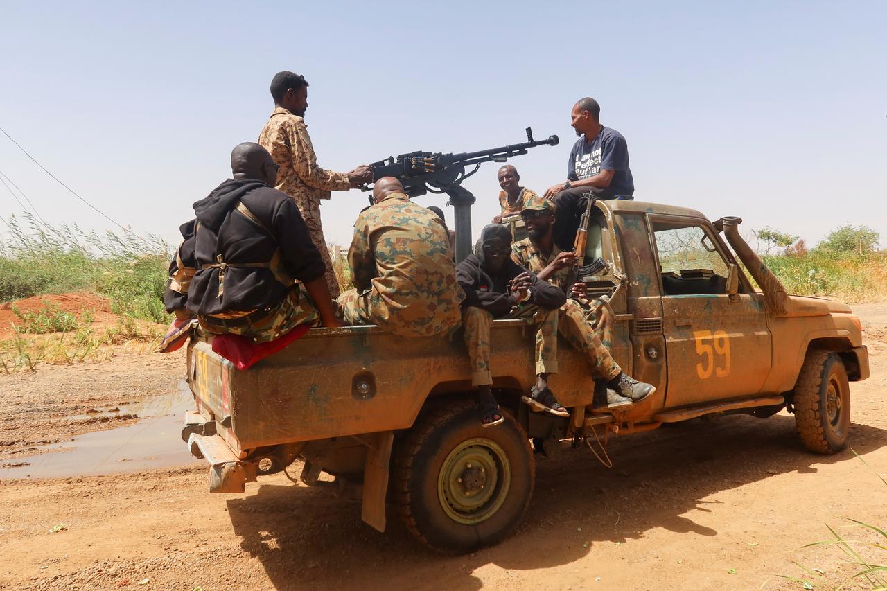 Members of Sudanese armed forces sit on an army vehicle in Omdurman