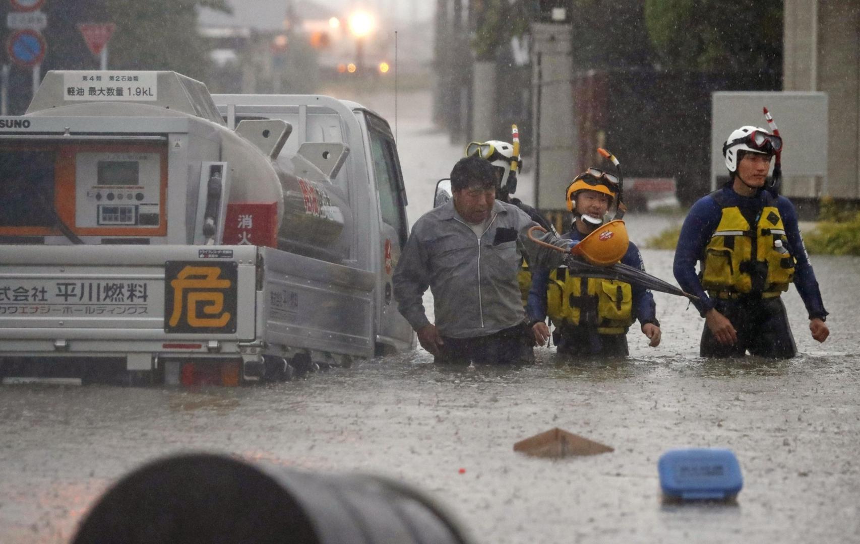 A man (L) is rescued by police after his vehicle became stuck on a road in the Fukuoka Prefecture city of Omuta on July 7, 2020, as torrential rain continues to hit Japan's southwestern region of Kyushu. (Kyodo)
==Kyodo
 Photo via Newscom Newscom/PIXSELL