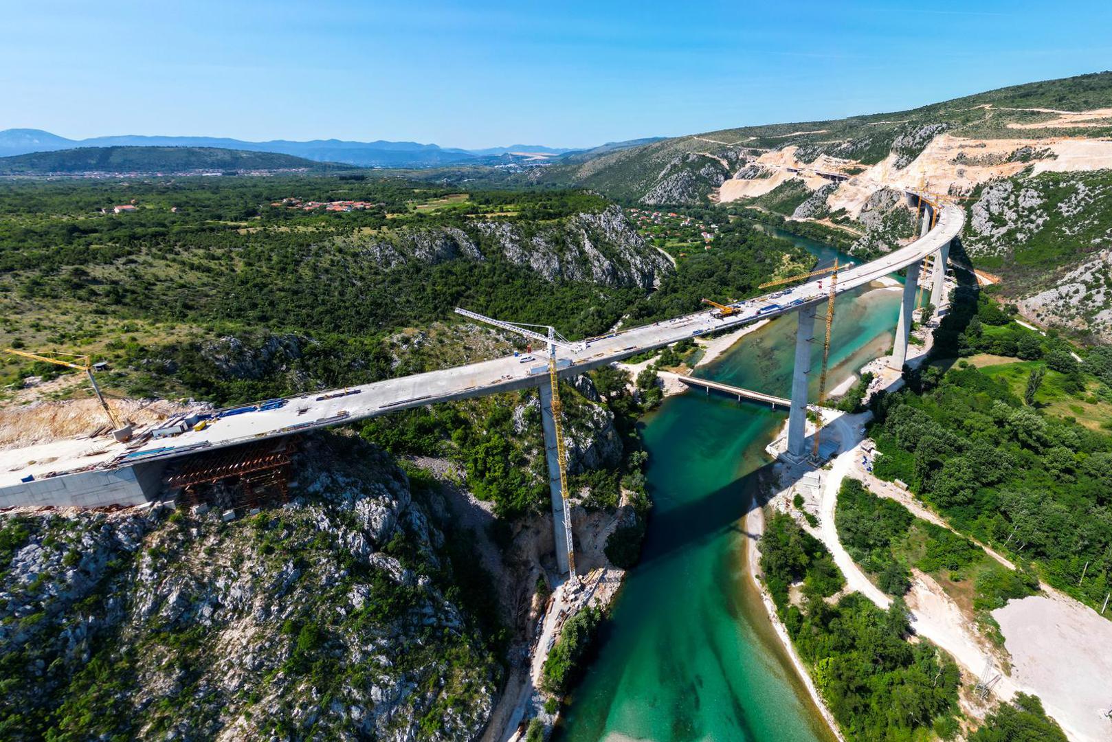 18.06.2023.,Capljina -  Jedan od najvisih mostova u regiji, most Pocitelj uskoro ce biti  spojen s lijevom obalom Neretve. Most Pocitelj visok je nesto vise od stotinu metara, dok njegova duzina iznosi 918 metara. Most ce imati dva vozna traka u svakom smjeru, te je projektiran za brzinu do 130 kilometara na sat. Specificnost ovog mosta je da se citava sirina raspona nalazi na jednostrukom nizu stupova, tj, kolnici nisu fizicki odvojeni. Most Pocitelj najveci je objekt na koridoru Vc. 


 Photo: Denis Kapetanovic/PIXSELL