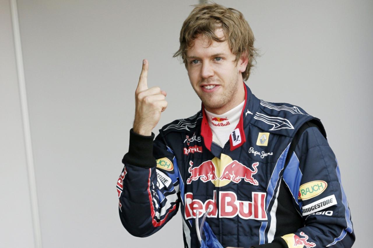 'Red Bull\'s German driver Sebastian Vettel celebrates in the parc ferme of the Silverstone circuit on July 10, 2010 after the qualifying session of the Formula One British Grand Prix. Red Bull\'s Ger