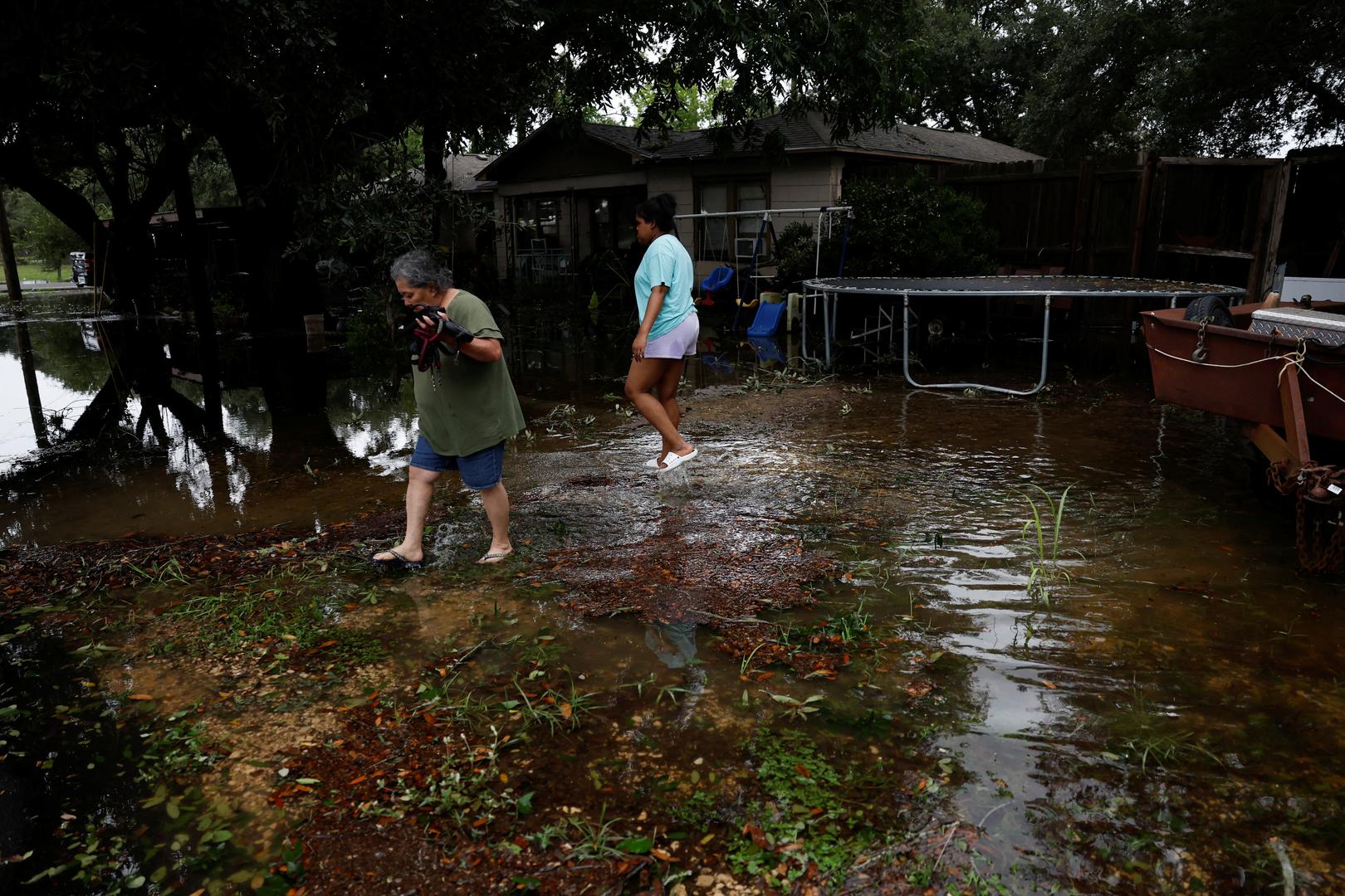 People walk in a flooded yard in the aftermath of Hurricane Beryl, in Rosenberg, Texas, U.S., July 8, 2024. REUTERS/Daniel Becerril Photo: DANIEL BECERRIL/REUTERS