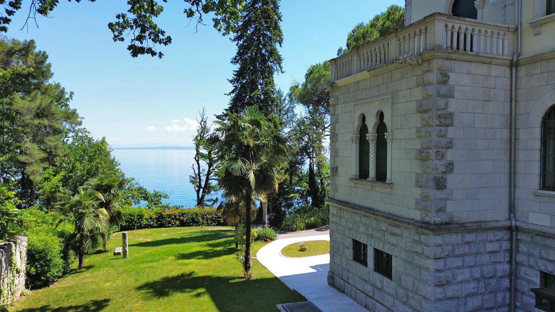 Ova višekatnica ima visoko potkrovlje i tlocrt gotovo kvadratnog oblika. Na istočnoj strani prema moru, nalazi se široki središnji rizalit. Raskošni trijem se proteže u prizemlju, a na desnom kraju pročelja ističe se veliki pravokutni izbočeni dio. Na južnom pročelju nalazi se manji suterenski izbočeni dio. 