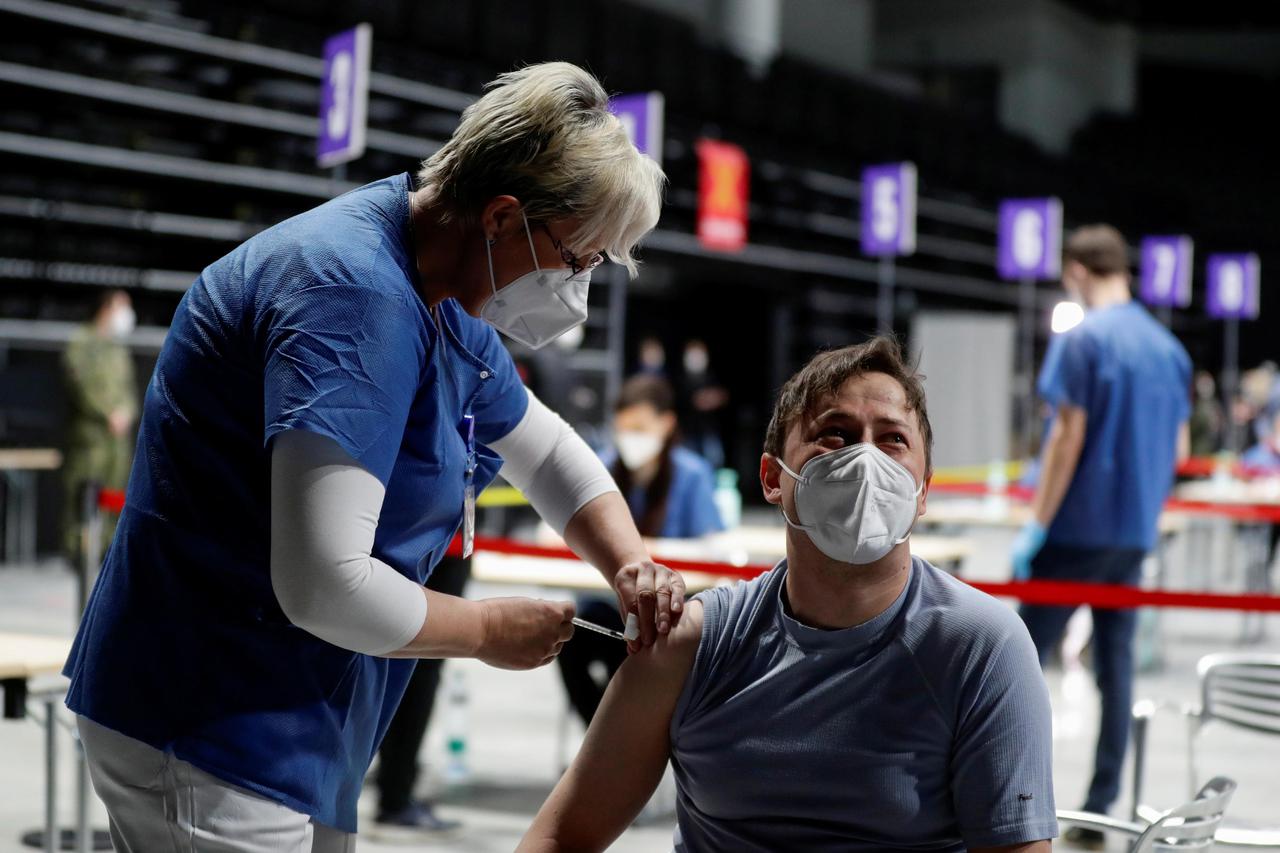 FILE PHOTO: A man receives a dose of the coronavirus disease (COVID-19) vaccine during a trial run of the national vaccination centre located inside the O2 Arena in Prague