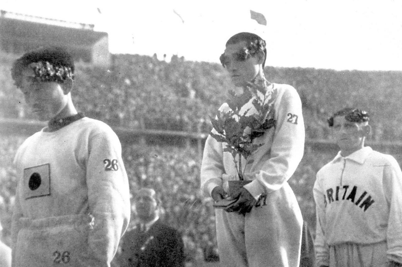 The gold medallist for a marathon at the 1936 Berlin Olympic Games, Sohn Kee-chung stands on the podium with his head lowered instead of looking at Japan's rising-sun flag in this photo taken in Berlin