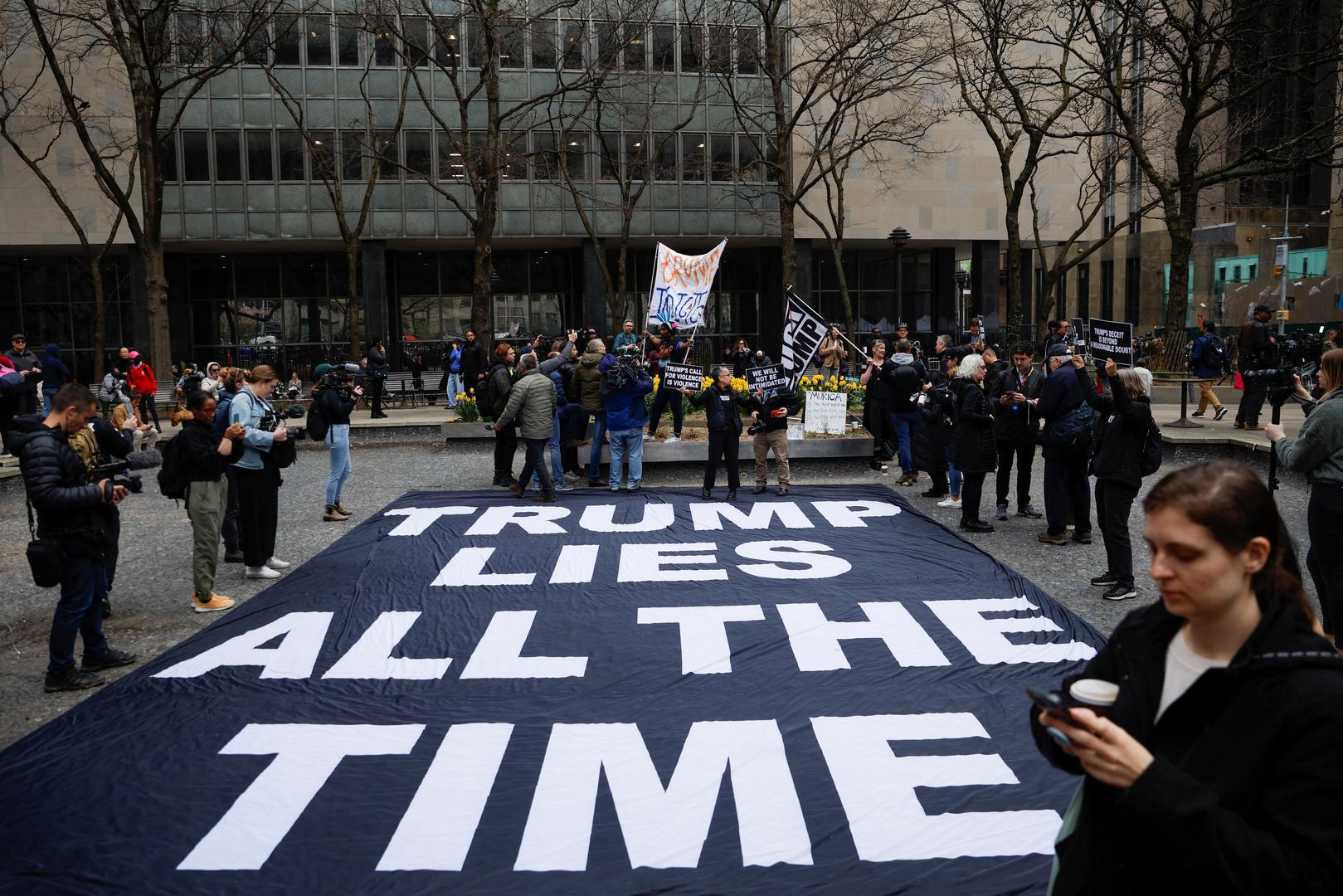 People gather around a banner set by anti-Trump protesters outside Manhattan Criminal Courthouse, after former U.S. President Donald Trump's indictment by a Manhattan grand jury following a probe into hush money paid to porn star Stormy Daniels, in New York City, U.S., April 4, 2023. REUTERS/Amanda Perobelli Photo: AMANDA PEROBELLI/REUTERS