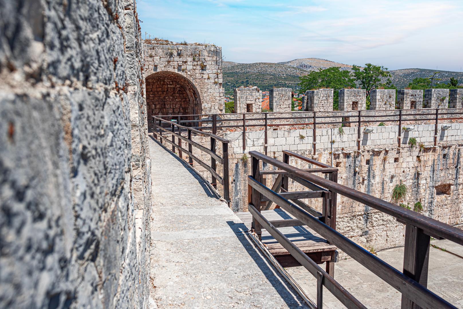 Trogirski stari grad: Zbog svog zemljopisnog položaja Trogir je oduvijek bio savršeno mjesto za život. Sa svojom prirodno zaštićenom lukom, brojnim izvorima pitke vode, plodnom zemljom u unutrašnjosti i kamenom iz lokalnih kamenoloma, Trogir je naseljen već više od 3600 godina. Ovaj mediteranski grad privlačio je mnoge velike majstore još od vremena starih Grka koji su ovdje stvorili neka od svojih najpoznatijih remek-djela. Trogir je jedinstveni primjer u povijesti europske arhitekture i grad s najvećim brojem znakova ili kamenih oznaka u Europi. Svaki ima svoje značenje. Neke od njih označavaju završetak gradnje, neke predstavljaju osobni potpis majstora, a neke su uklesane zavjetne molitve. Majstori su također klesali igre u kamenu, poput šaha, koji im je služio kao zabava tijekom stanke u izgradnji.