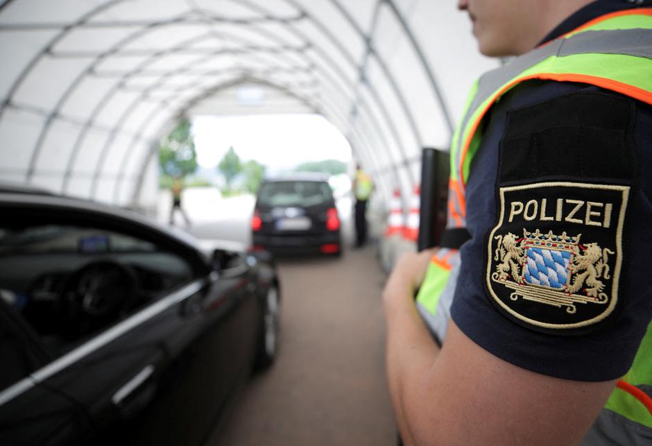 FILE PHOTO: A German police officer controls a car at a checkpoint between the Austrian and German border in Kiefersfelden