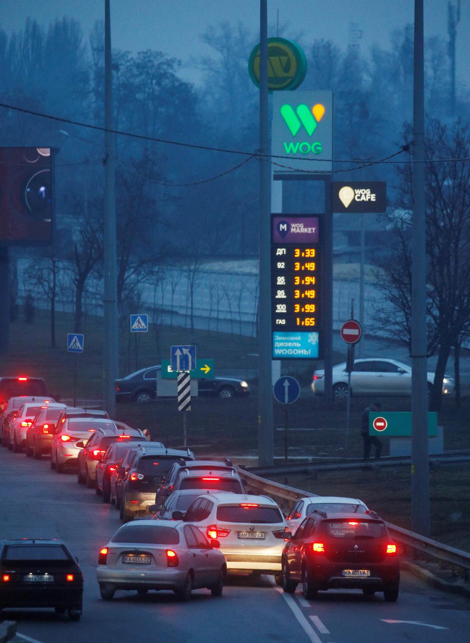 Cars stand in line near a gas station as they wait to fuel up in Kyiv