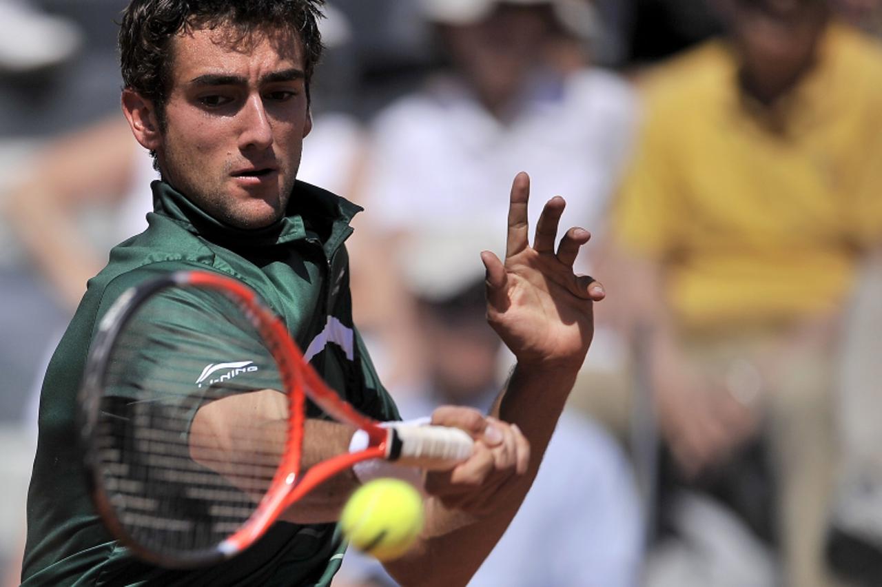 'Marin Cilic of Croatia returns a ball to Spain\'s Rafael Nadal during their Rome Open tennis tournament quarter-final match in Rome\'s Foro Italico on May 13, 2011. Nadal defeated Cilic 6-1, 6-3. AFP