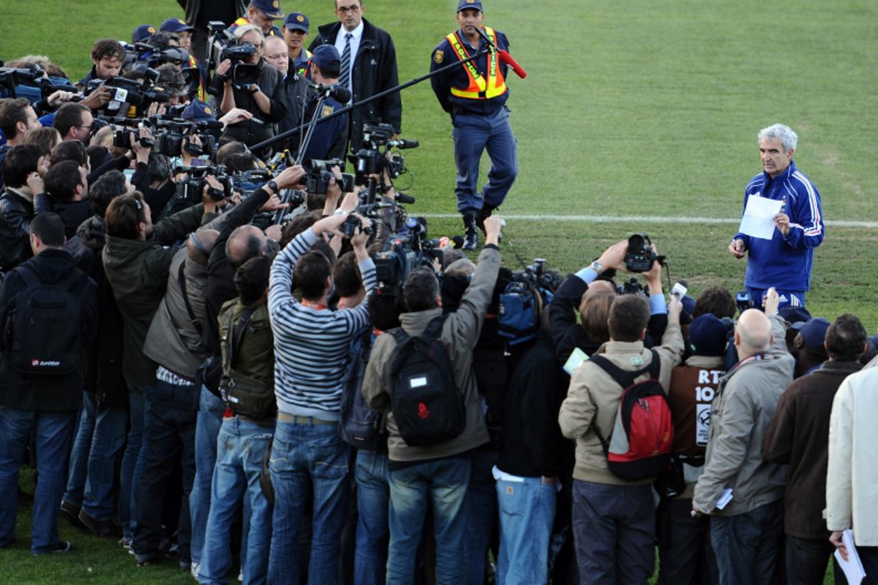 'France\'s coach Raymond Domenech (R) speaks in front of journalists at the Fields of Dreams stadium in Knysna on June 20, 2010 during the 2010 World Cup football tournament. The French World Cup squa