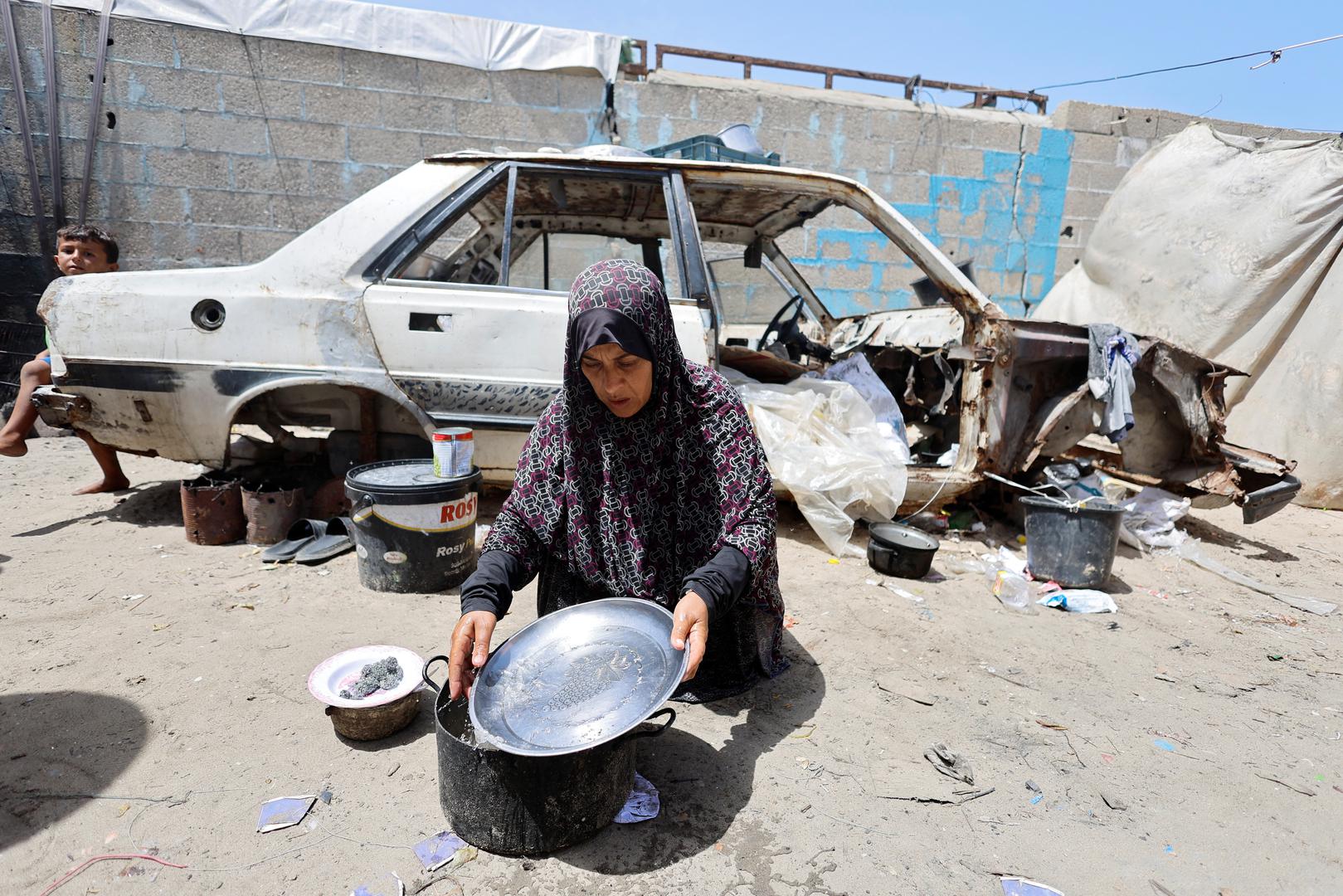 A displaced Palestinian woman washes a utensil, after she had to flee her house and shelter in a tent due to Israel's military offensive, amid the ongoing conflict between Israel and Palestinian Islamist group Hamas, in Rafah, in the southern Gaza Strip May 23, 2024. REUTERS/Mohammed Salem Photo: MOHAMMED SALEM/REUTERS