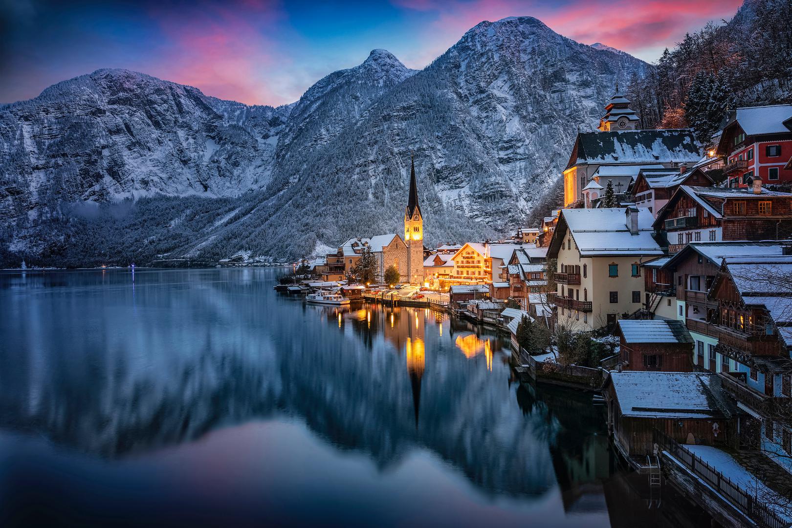 1. Hallstatt, Austrija – Selo kao iz bajke: Smješten uz mirno jezero i okružen snježnim Alpama, Hallstatt je prava zimska idila. Tradicionalne drvene kuće, rudnici soli i Skywalk vidikovac nude nezaboravne trenutke. Posjetitelji mogu uživati u šetnji starim gradom, istražiti fascinantne rudnike soli i diviti se spektakularnom pogledu s vidikovca Skywalk. Ove aktivnosti pružaju jedinstveno iskustvo koje obuhvaća povijesnu i prirodnu ljepotu Hallstatta. Također bi svakako trebali probati Kaiserschmarrn, tradicionalno austrijsko jelo koje se sastoji od karameliziranih palačinki posluženih s ukusnim kompotom od šljiva. Najbolje vrijeme za posjet Hallstattu je prosinac, kada grad odiše božićnim ugođajem, ili siječanj, koji nudi mirniju zimsku atmosferu za opušteno istraživanje ovog čarobnog mjesta.