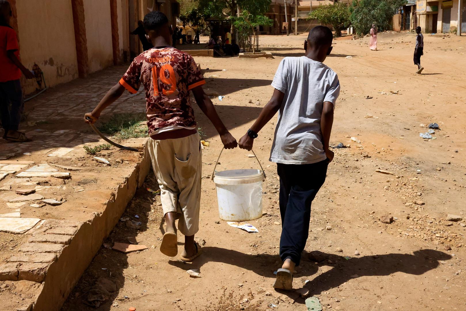 People carry water during clashes between the paramilitary Rapid Support Forces and the army in Khartoum North, Sudan, April 22, 2023. REUTERS/Mohamed Nureldin Abdallah Photo: MOHAMED NURELDIN ABDALLAH/REUTERS