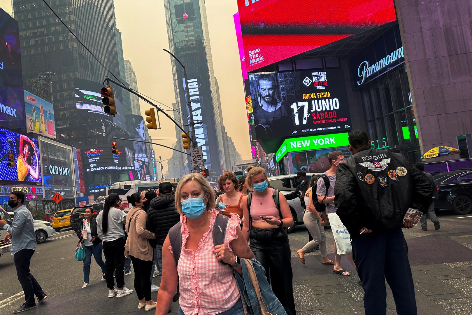 People walk in Times Square as Manhattan is shrouded in haze and smoke which drifted south from wildfires in Canada, in New York City, New York, U.S., June 7, 2023. REUTERS/Maye-E Wong Photo: MAYE-E WONG/REUTERS