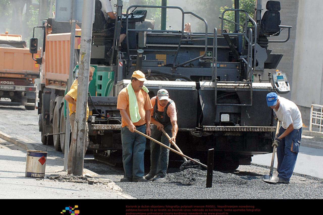 '05.07.2012., Sisak - Preporuke Ministarstva zdravlja o izbjegavanju napornog fizickog rada od 10 do 17 sati, ne mogu se, na njihovu zalost, pridrzavati radnici Cesta Sisak koji asfaltiraju Ulicu Mati