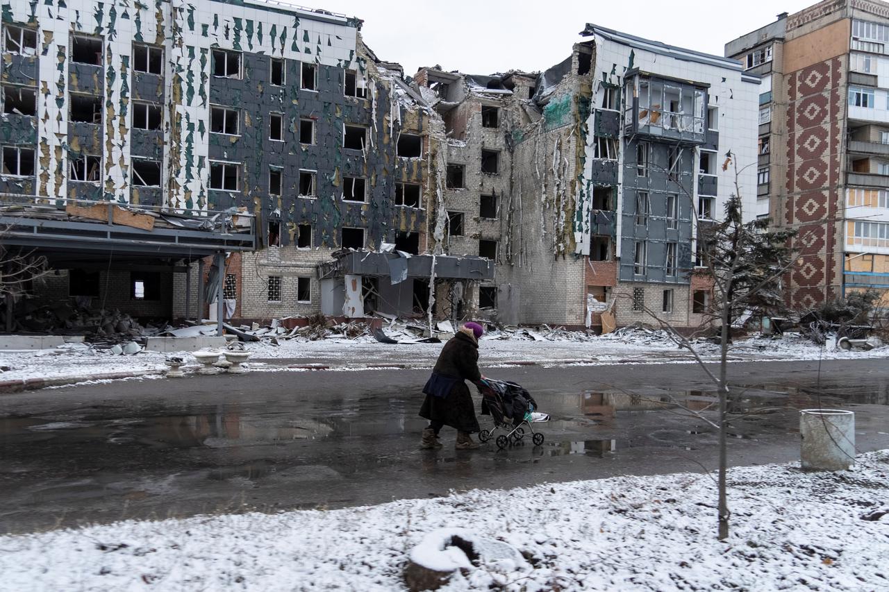 A woman walks past a building damaged by a Russian military strike in the town of Pokrovsk