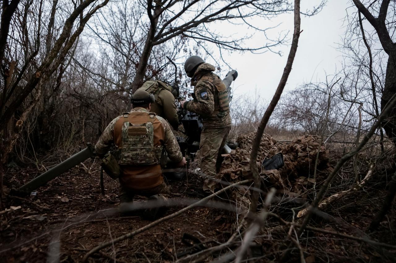 Servicemen of the National Guard of Ukraine fire a howitzer towards Russian troops at a position in a front line in Kharkiv region