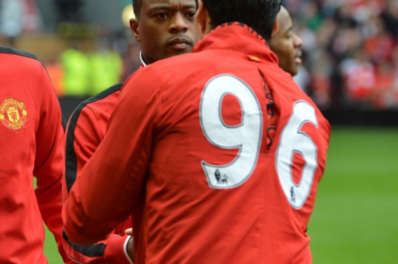 'Liverpool\'s Uruguayan striker Luis Suarez (R) shakes hands with Manchester United\'s Senegalese-born French defender Patrice Evra (L) before the English Premier League football match between Liverpo