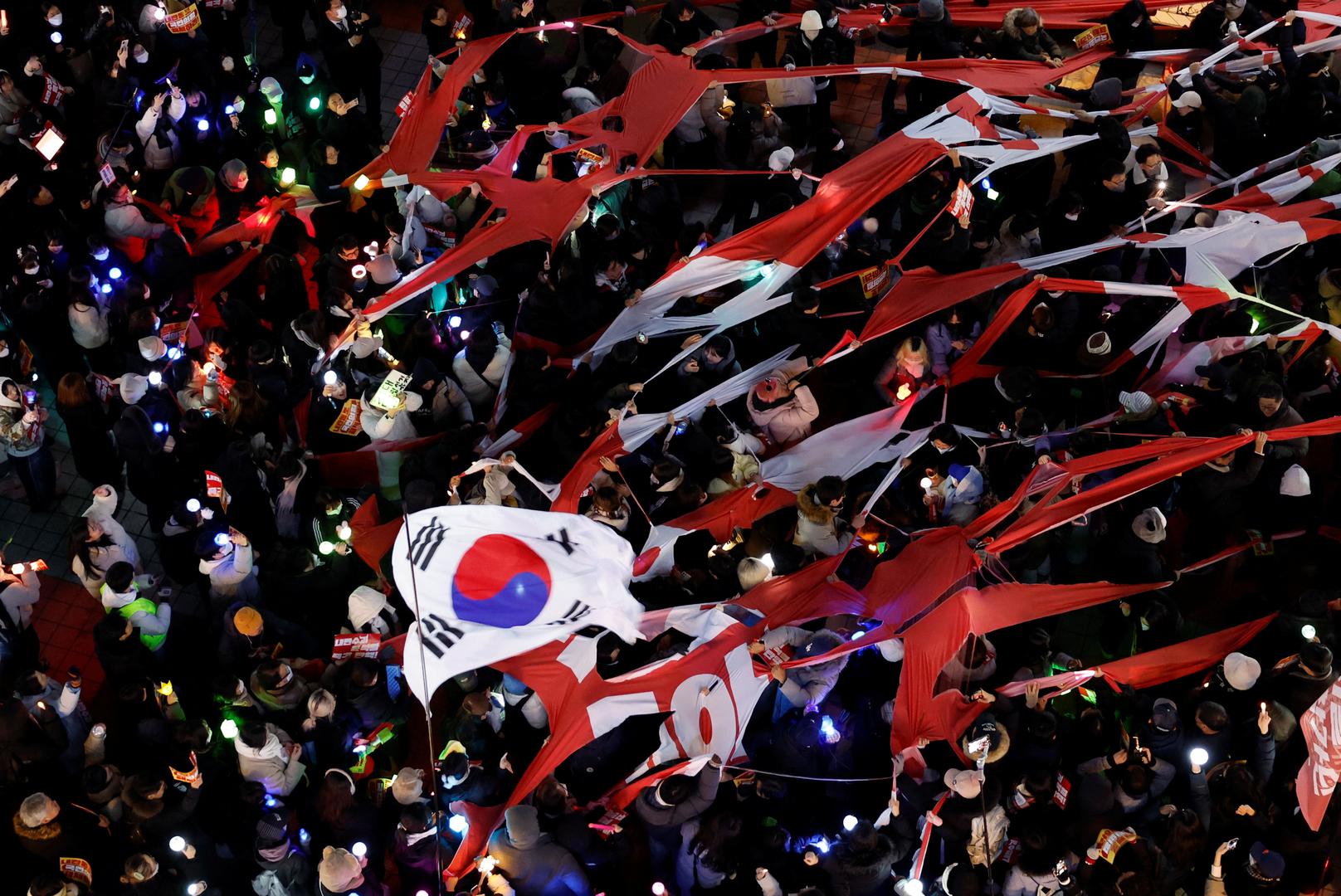 Protesters tear a banner representing the flag of the ruling People Power Party as they attend a rally calling for the impeachment of South Korean President Yoon Suk Yeol, who declared martial law, which was reversed hours later, in front of the headquarters of the ruling People Power Party, in Seoul, South Korea, December 9, 2024.  REUTERS/Kim Kyung-Hoon Photo: KIM KYUNG-HOON/REUTERS