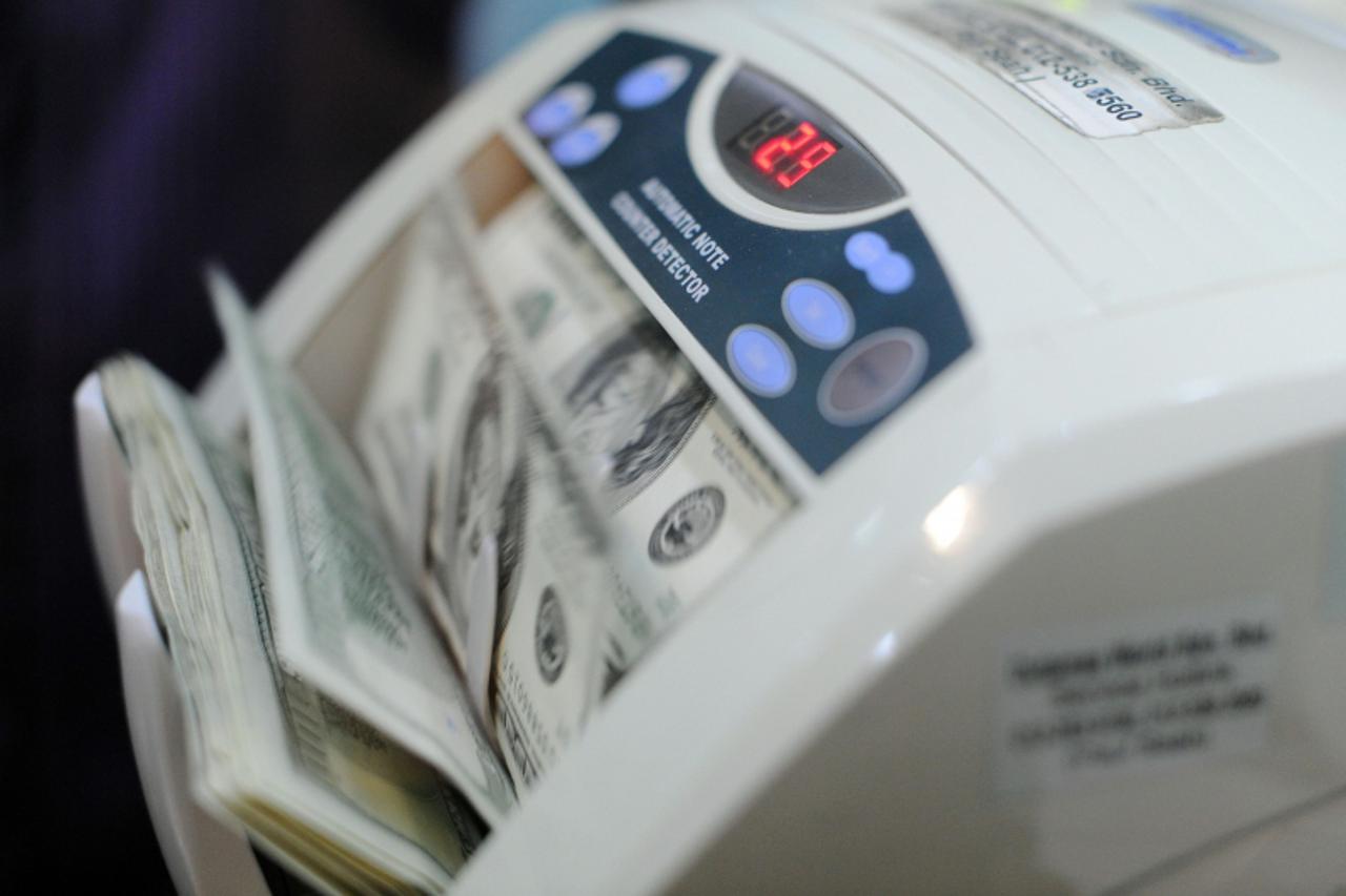 'US dollars are counted at a forex exchange inside a shopping mall in Kuala Lumpur on April 16, 2011. Malaysia's central bank is unexpected to raise interest rate as a hike may dampen economic growth