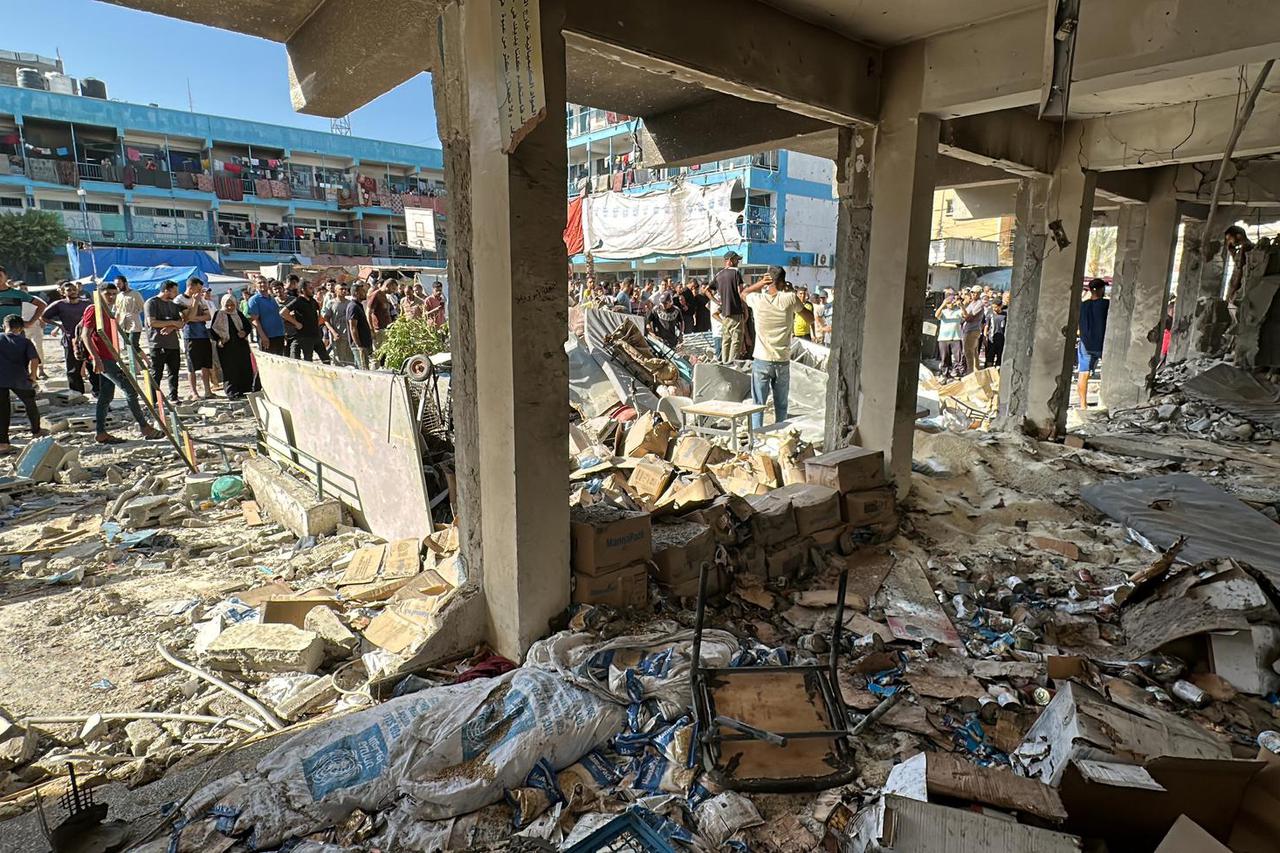 Palestinians inspect a school sheltering displaced people, after it was hit by an Israeli strike, amid the Israel-Hamas conflict, in Nuseirat in the central Gaza Strip