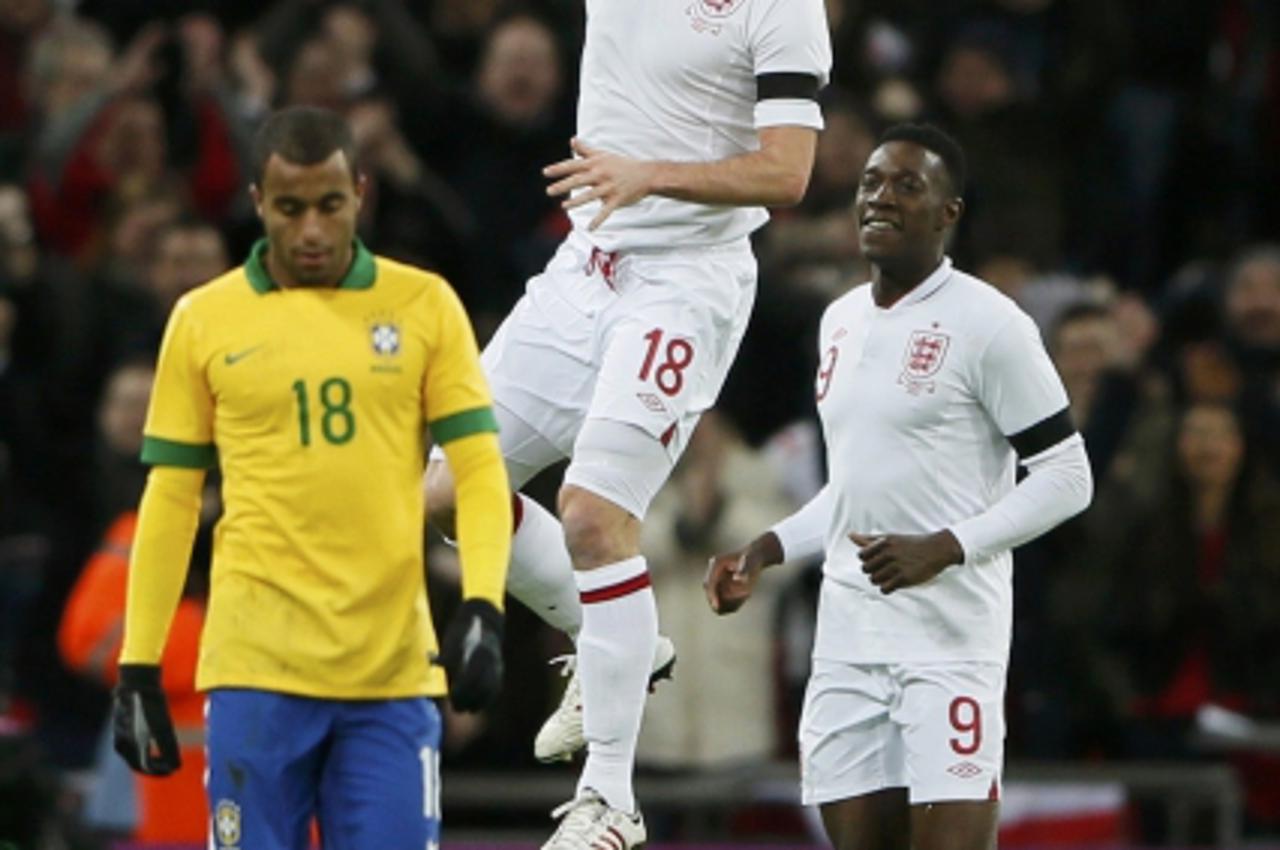 'England\'s Frank Lampard (C) celebrates with team mate Daniel Welbeck after scoring against Brazil during their international friendly soccer match at Wembley stadium in London February 6, 2013.     