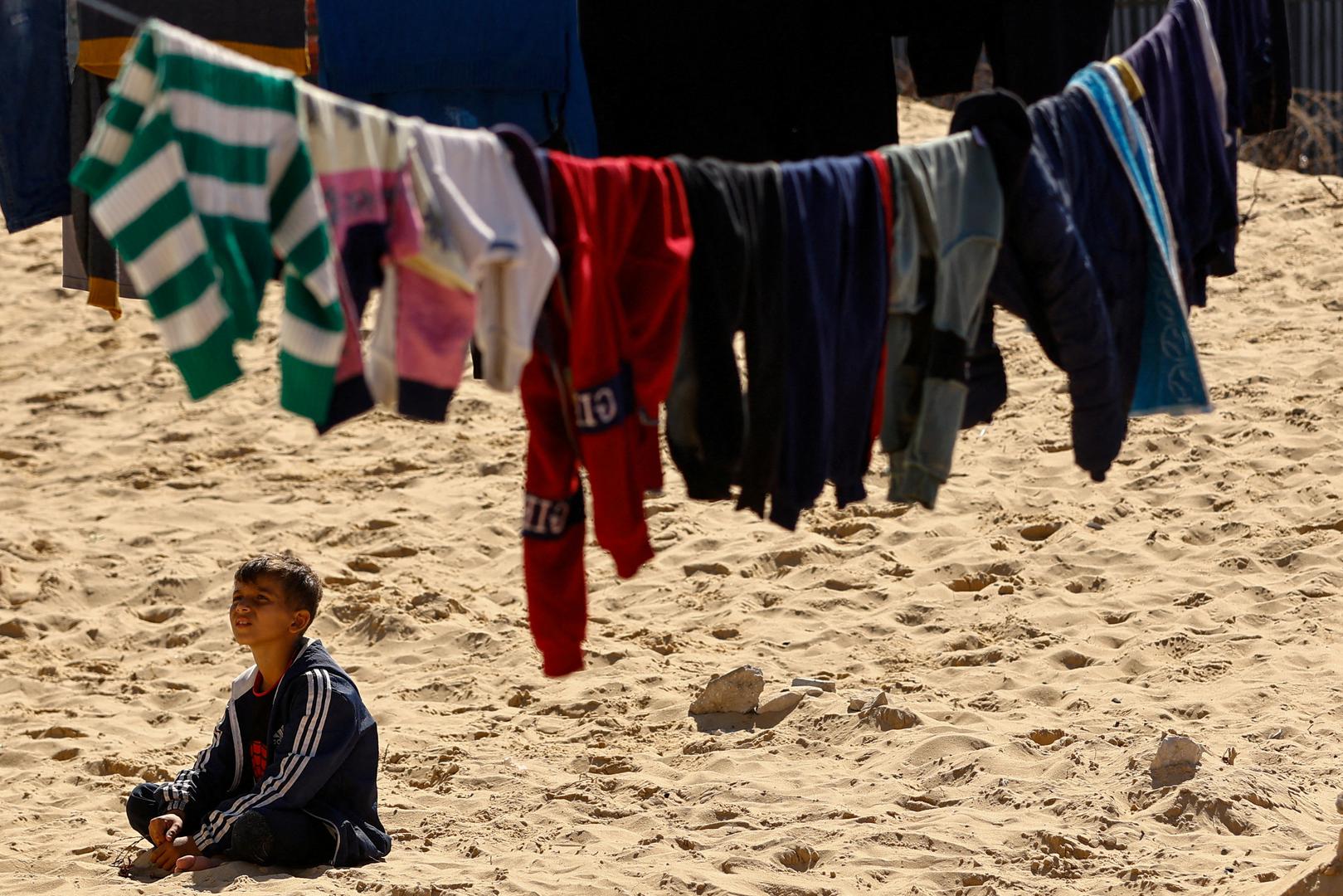 A boy sits next to hanging clothes, as displaced Palestinians, who fled their houses due to Israeli strikes, take shelter in a tent camp, amid the ongoing conflict between Israel and the Palestinian Islamist group Hamas, at the border with Egypt, in Rafah in the southern Gaza Strip, February 8, 2024. REUTERS/Ibraheem Abu Mustafa Photo: IBRAHEEM ABU MUSTAFA/REUTERS