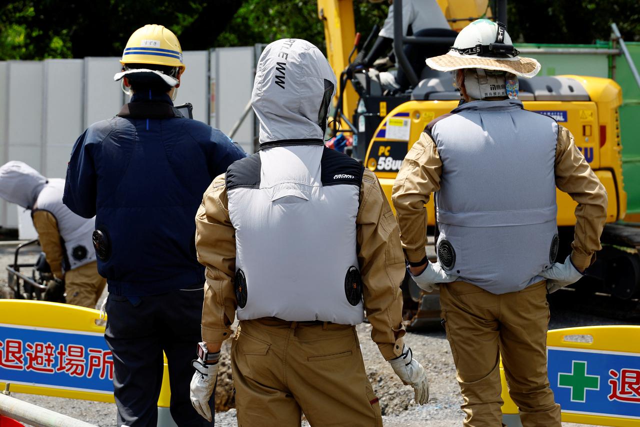 Workers wear cooling fan jackets at a construction site in Ayase