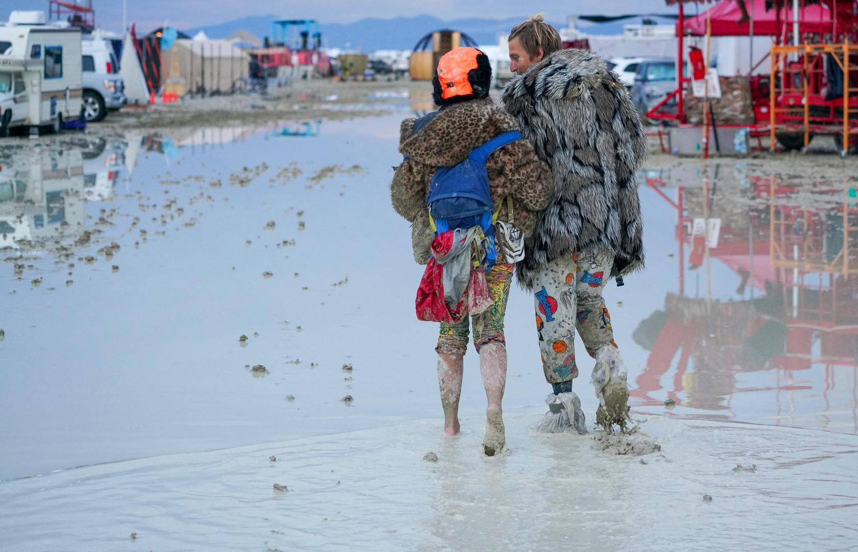 Dub Kitty and Ben Joos, of Idaho and Nevada, walk through the mud at Burning Man after a night of dancing with friends in Black Rock City, in the Nevada desert, after a rainstorm turned the site into mud September 2, 2023.  Trevor Hughes/USA TODAY NETWORK via REUTERS  NO RESALES. NO ARCHIVES. Photo: USA TODAY/REUTERS