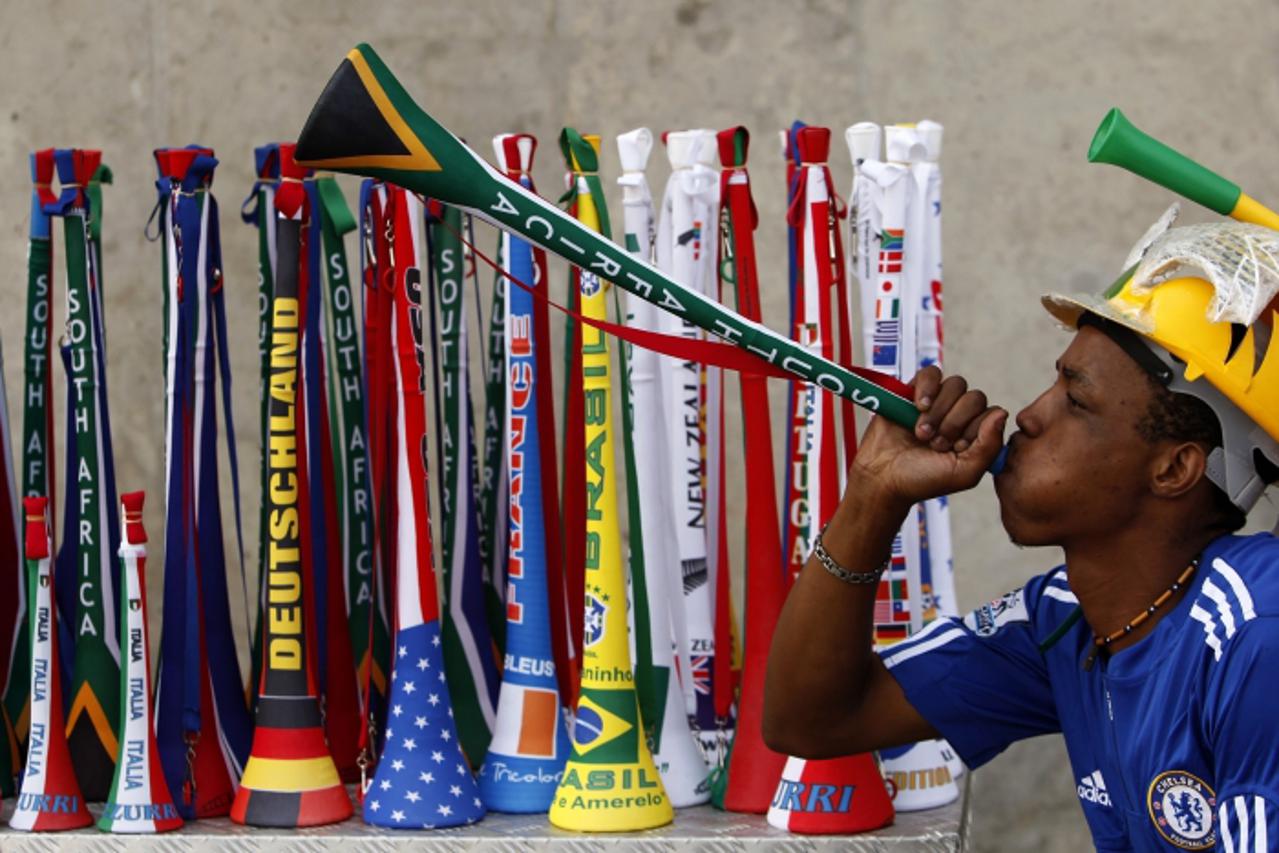 'Mpho Qhalane, a street vendor, blows a vuvuzela as he tries to attract customers during a test match at FNB stadium outside Soweto, March 26, 2010.  Johannesburg Soccer Legends and City of Johannesbu