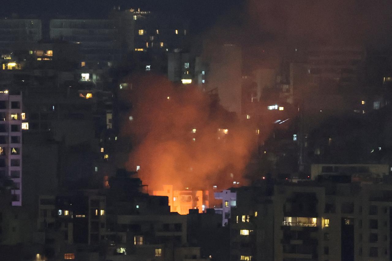 People and media workers gather at the site of an Israeli strike after Iran's parliament speaker Mohammad Baqer Qalibaf's visit, in Beirut