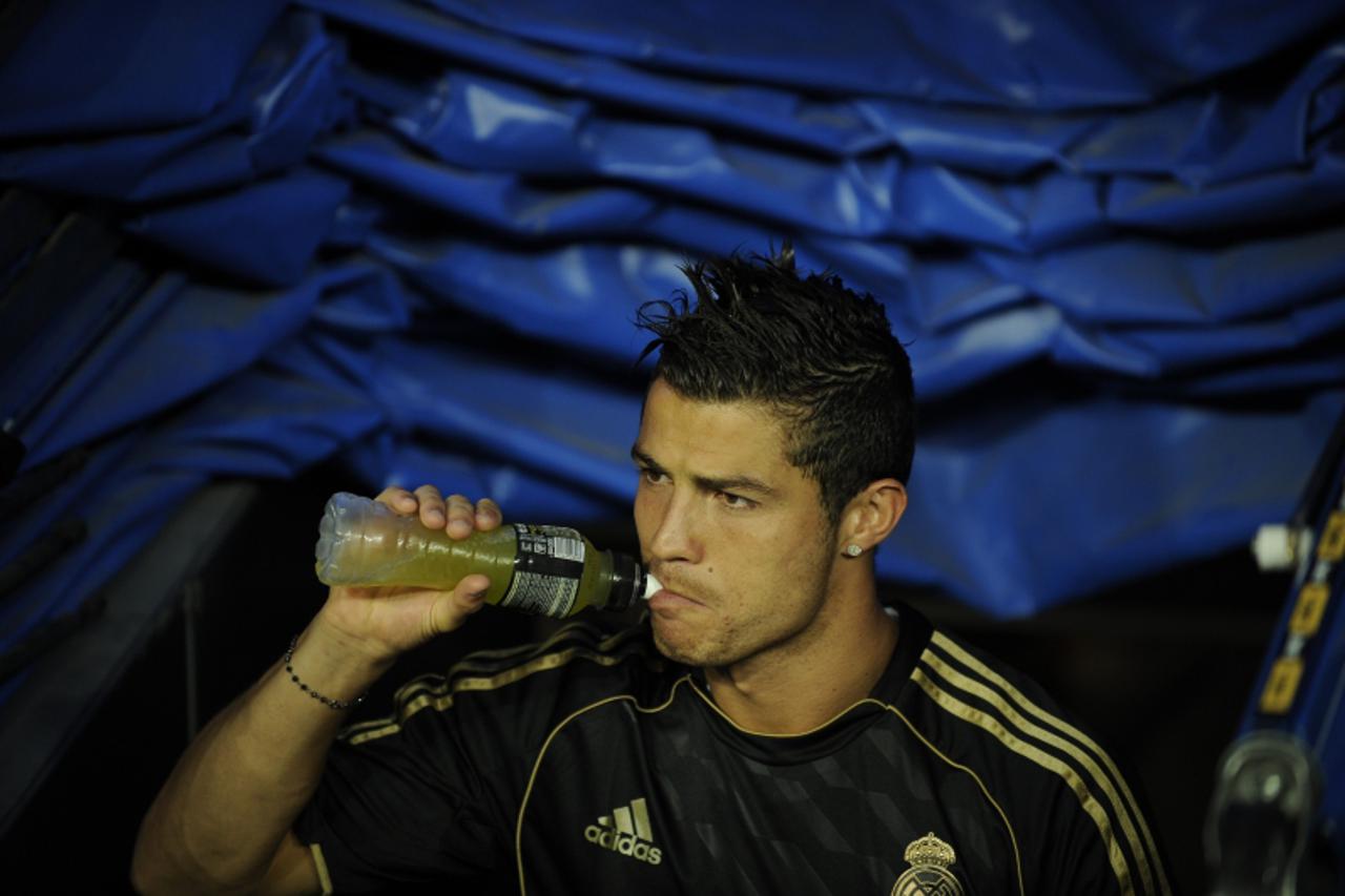 'Real Madrid\'s Portuguese forward Cristiano Ronaldo drinks a sports drink before his team\'s Santiago Bernabeu trophy match against Galatasaray at the Santiago Bernabeu Stadium, August 24, 2011 in Ma