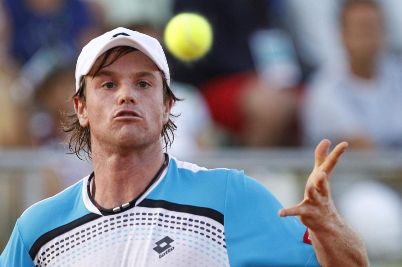 'Blaz Kavcic of Slovenia eyes the ball as he returns a shot to Potito Starace of Italy during their men\'s singles Davis Cup tennis match in Arzachena July 8, 2011. REUTERS/Max Rossi (ITALY - Tags: SP