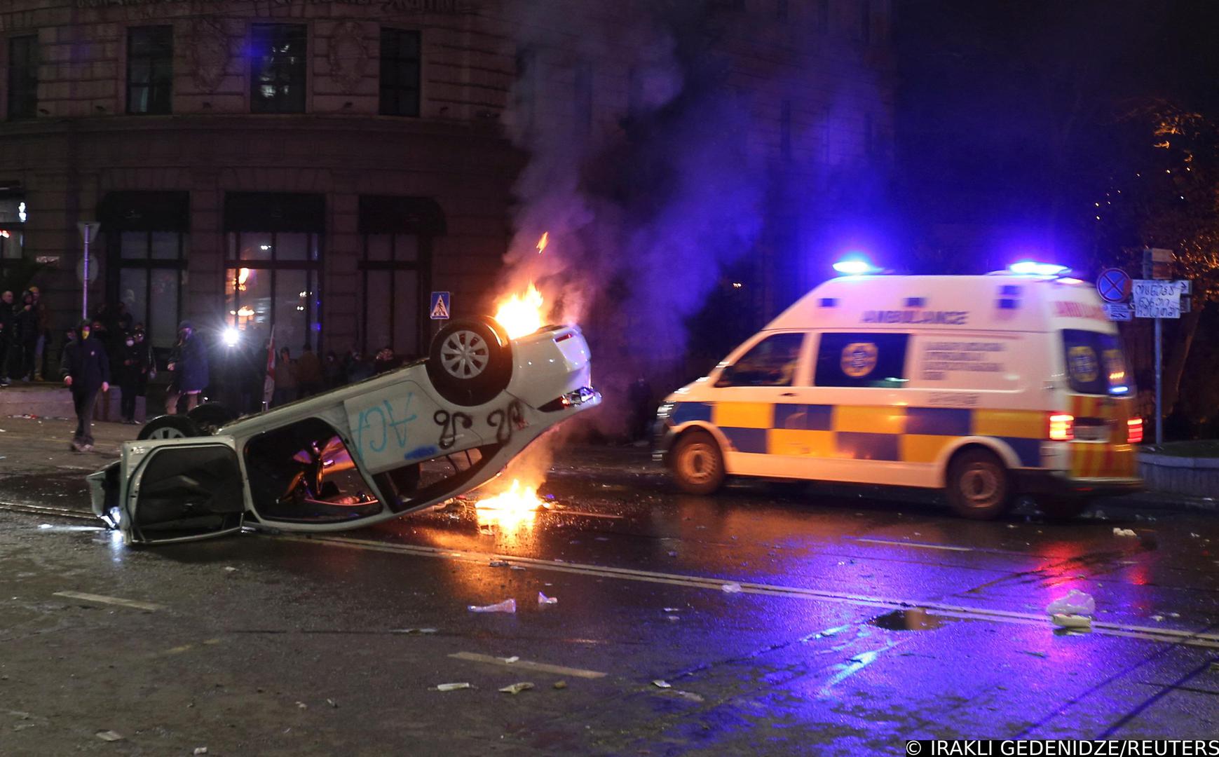 An ambulance drives past an overturned car set on fire during a protest against a draft law on "foreign agents", which critics say represents an authoritarian shift and could hurt Georgia's bid to join the European Union, in Tbilisi, Georgia, March 9, 2023. REUTERS/Irakli Gedenidze Photo: IRAKLI GEDENIDZE/REUTERS