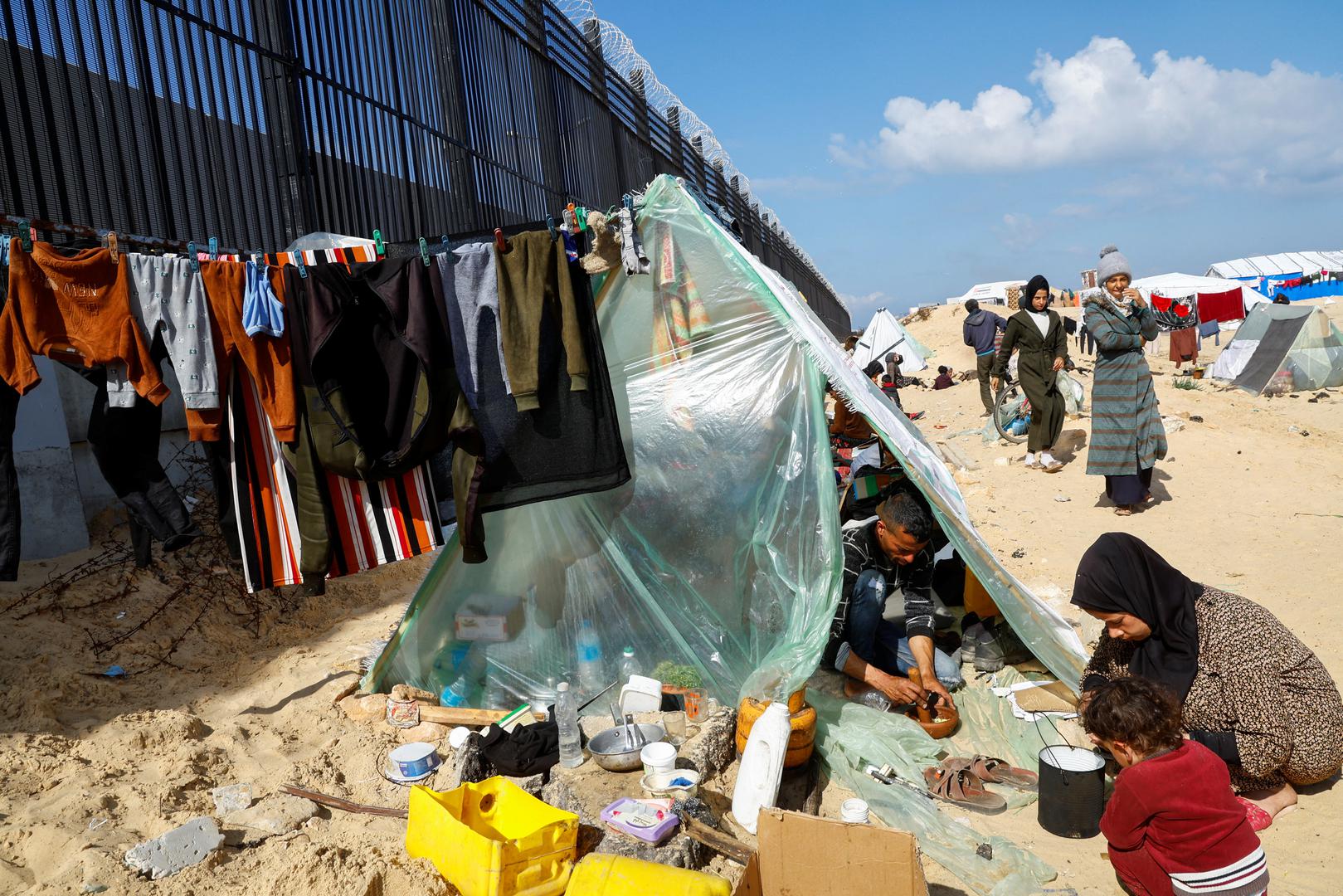 Displaced members of Palestinian Abu Mustafa family, who fled their house due to Israeli strikes, prepare food as they shelter at the border with Egypt, in Rafah in the southern Gaza Strip, February 10, 2024. REUTERS/Mohammed Salem Photo: MOHAMMED SALEM/REUTERS