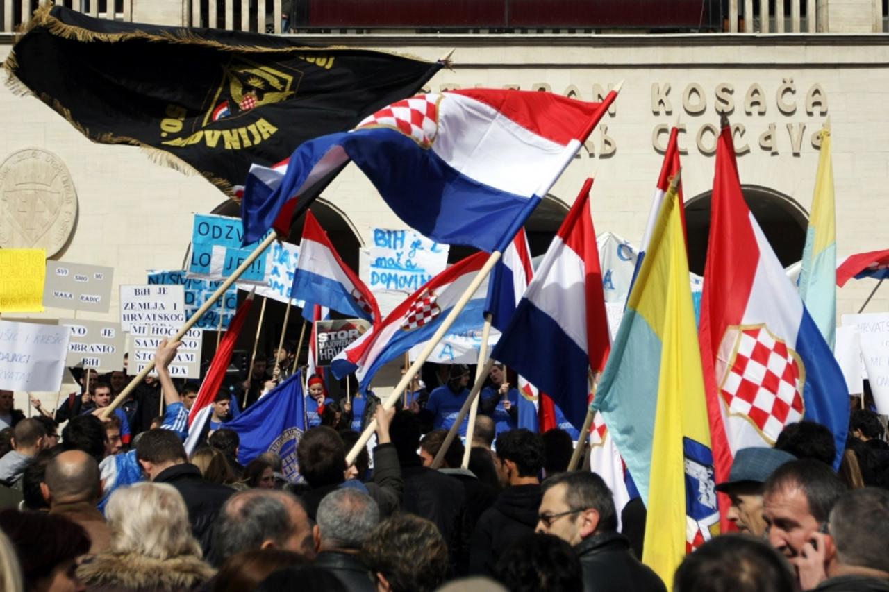 'Bosnian Croat youth wave flags in Mostar on March 17, 2011, during protest against systematic breaking of their constitutional rights through outvoting by Bosnian Muslim majority in Muslim-Croat Fede