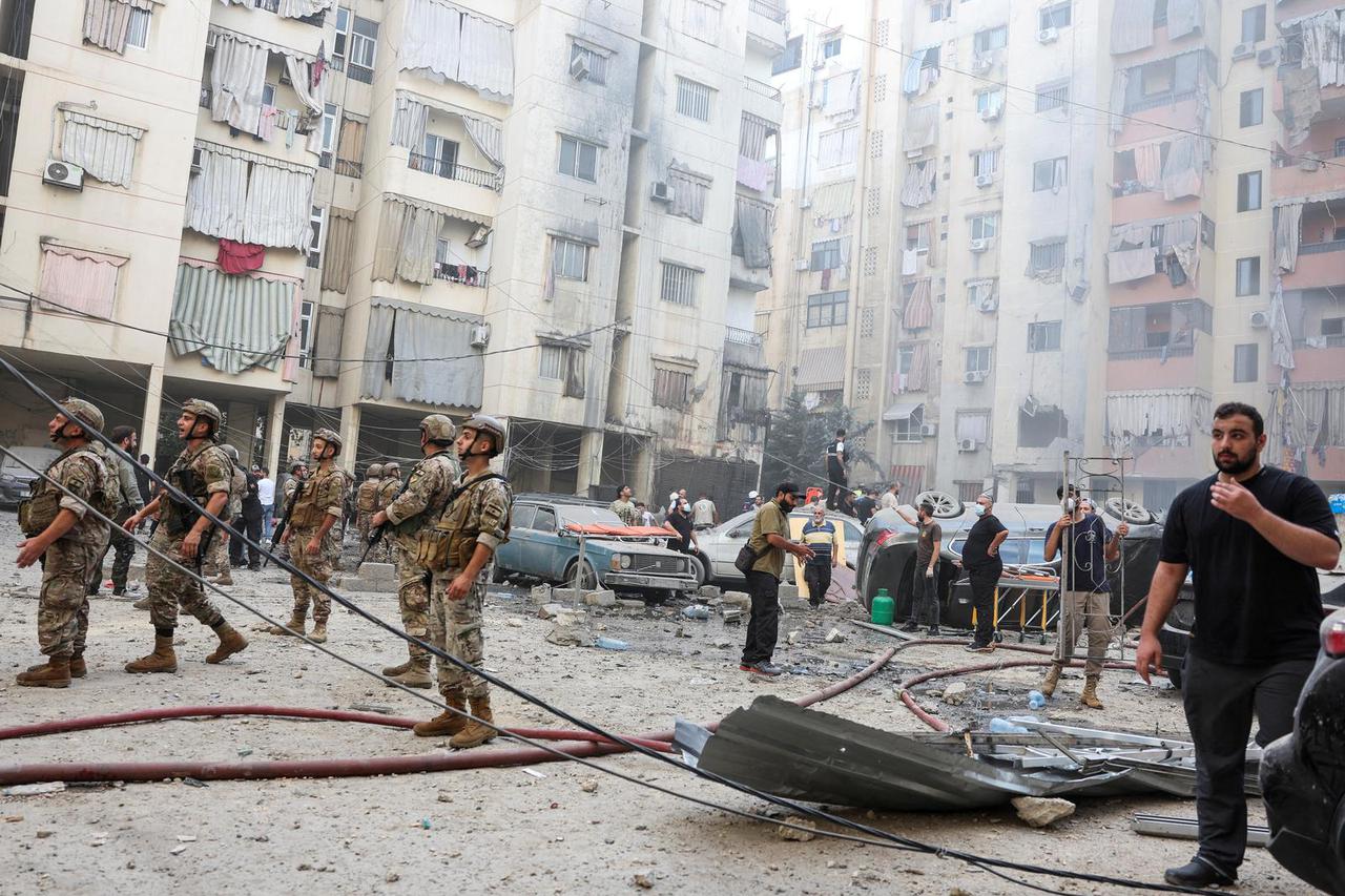 People inspect the site of an Israeli strike, in Beirut