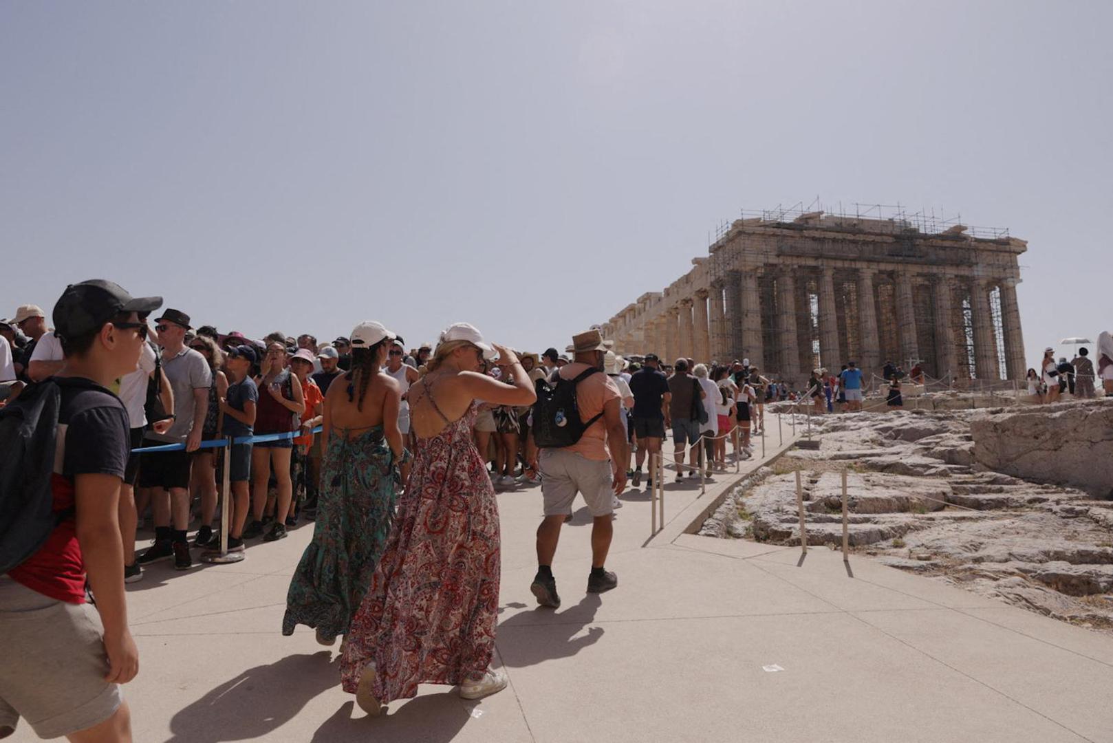 Visitors walk near the Parthenon temple atop the Acropolis hill, during a heatwave in Athens, Greece, July 14, 2023. REUTERS/Louiza Vradi Photo: LOUIZA VRADI/REUTERS