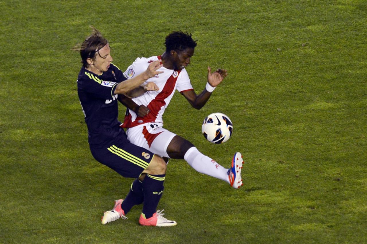 'Real Madrid\'s Croatian midfielder Luka Modric (L) vies with Rayo Vallecano\'s Guinean forward Lass Bangoura during the Spanish league football match Rayo Vallecano vs Real Madrid on September 24, 20