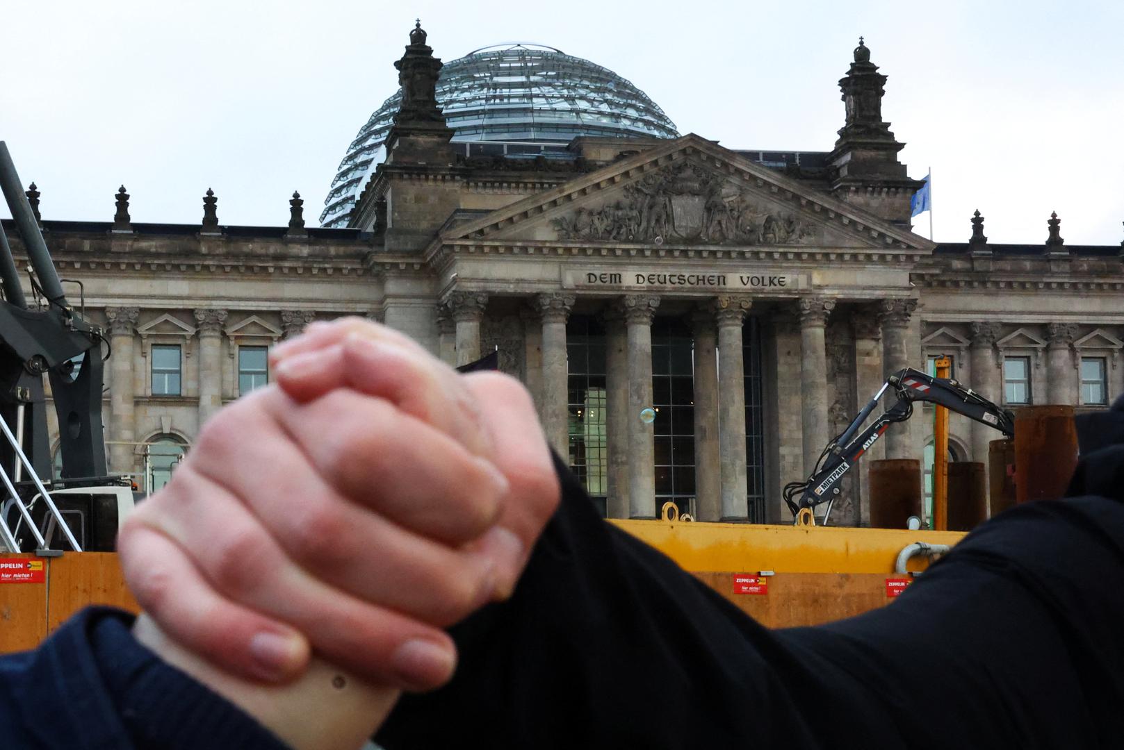 People hold hands as they gather to form a human chain around the Reichstag building, during a rally of the broad alliance "Hand in Hand" under the slogan "Wir sind die Brandmauer" ("We are the Firewall") to protest against right-wing extremism and for the protection of democracy, in Berlin, Germany February 3, 2024. REUTERS/Fabrizio Bensch Photo: Fabrizio Bensch/REUTERS