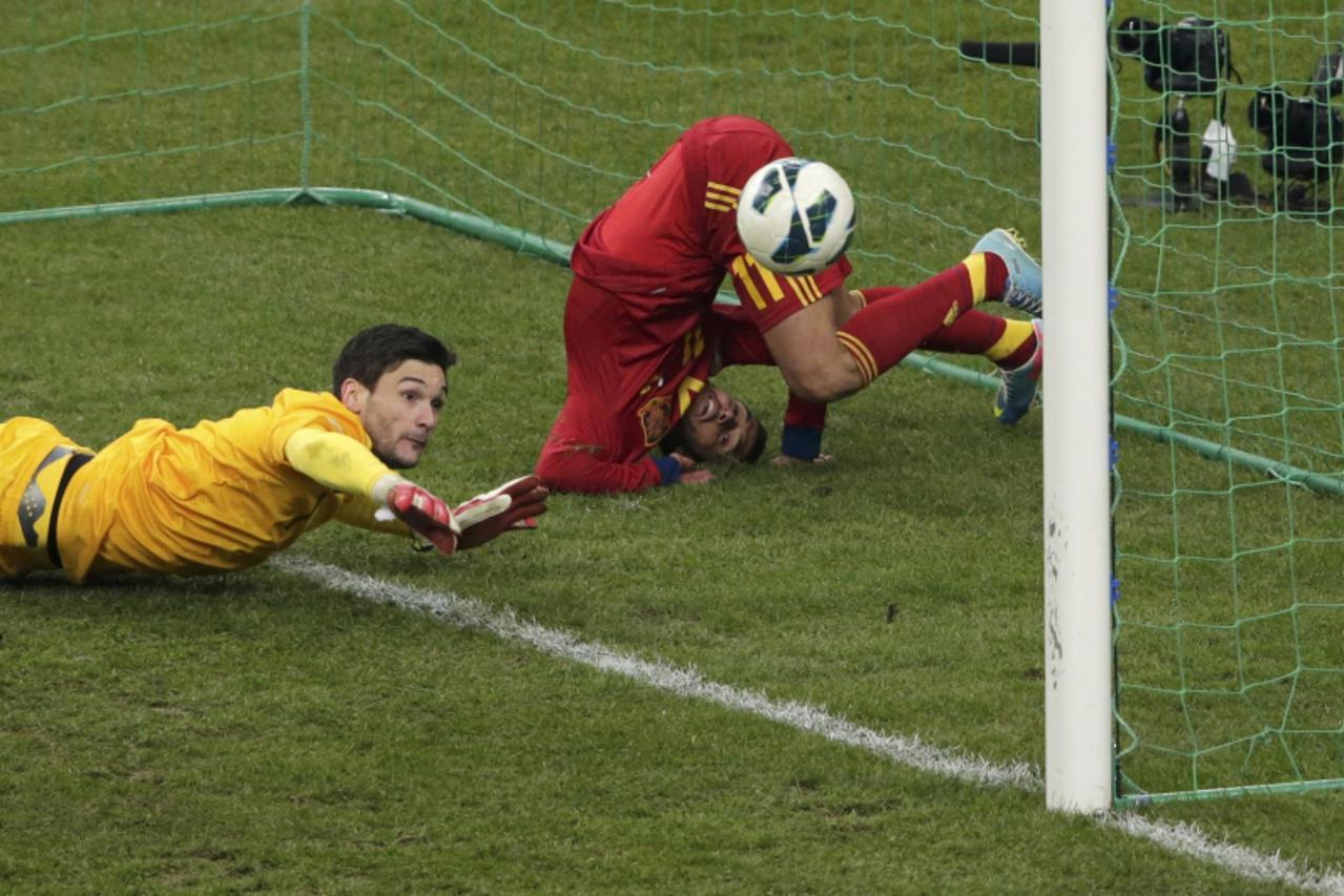 'Spain\'s Pedro Rodriguez Ledesma (R) scores against France\'s Hugo Lloris (L) during their 2014 World Cup qualifying soccer match at the Stade de France stadium in Saint-Denis, near Paris,  March 26,