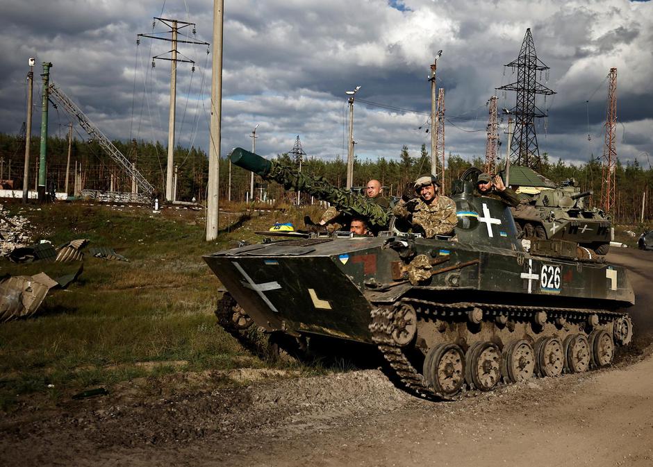 Ukrainians ride an armoured vehicle in Donesk region