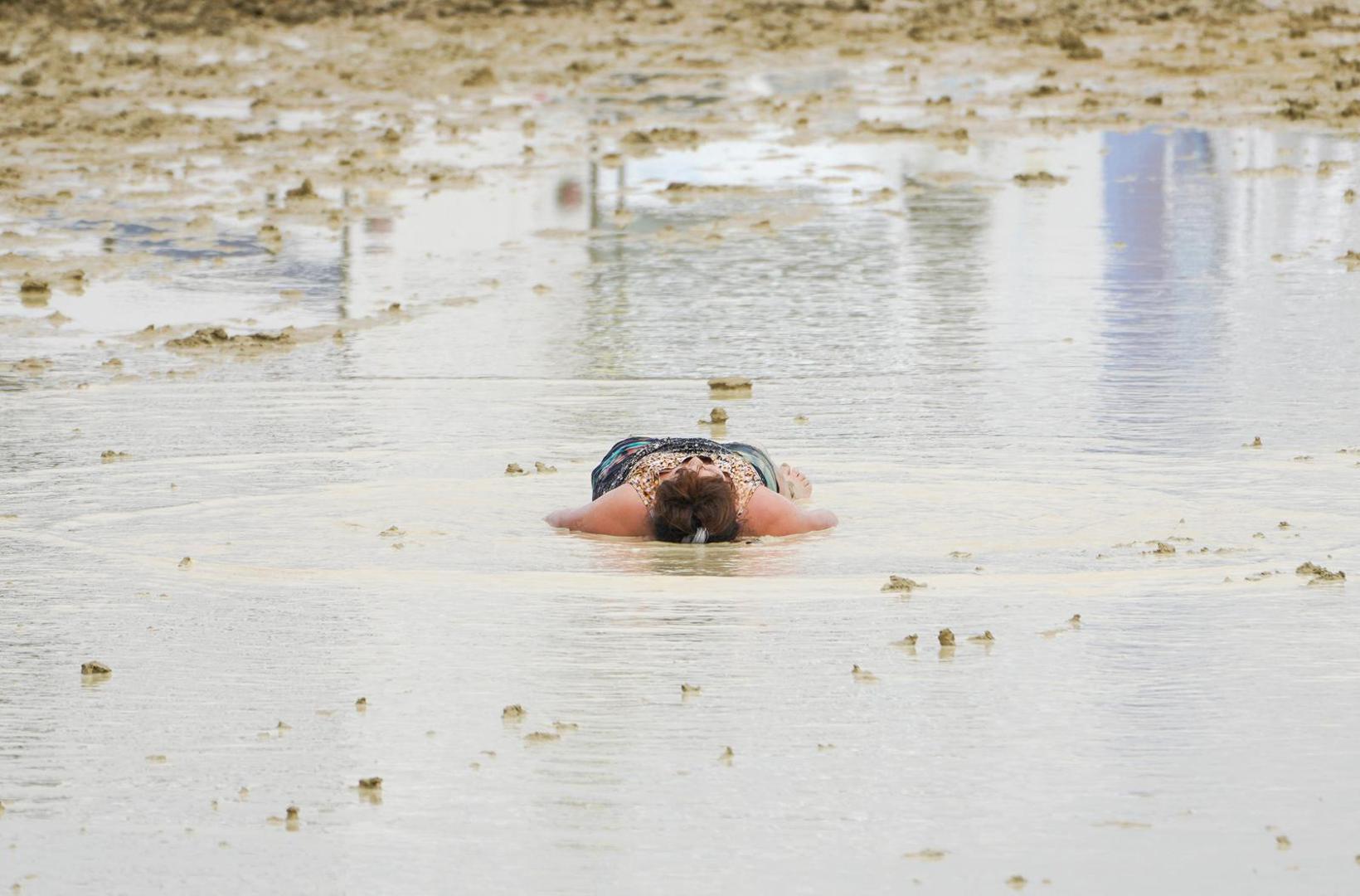 A Burning Man attendee lies down in the mud and water at the event in Black Rock City, in the Nevada desert, after a rainstorm turned the site into mud September 2, 2023.  Trevor Hughes/USA TODAY NETWORK via REUTERS  NO RESALES. NO ARCHIVES. Photo: USA TODAY/REUTERS